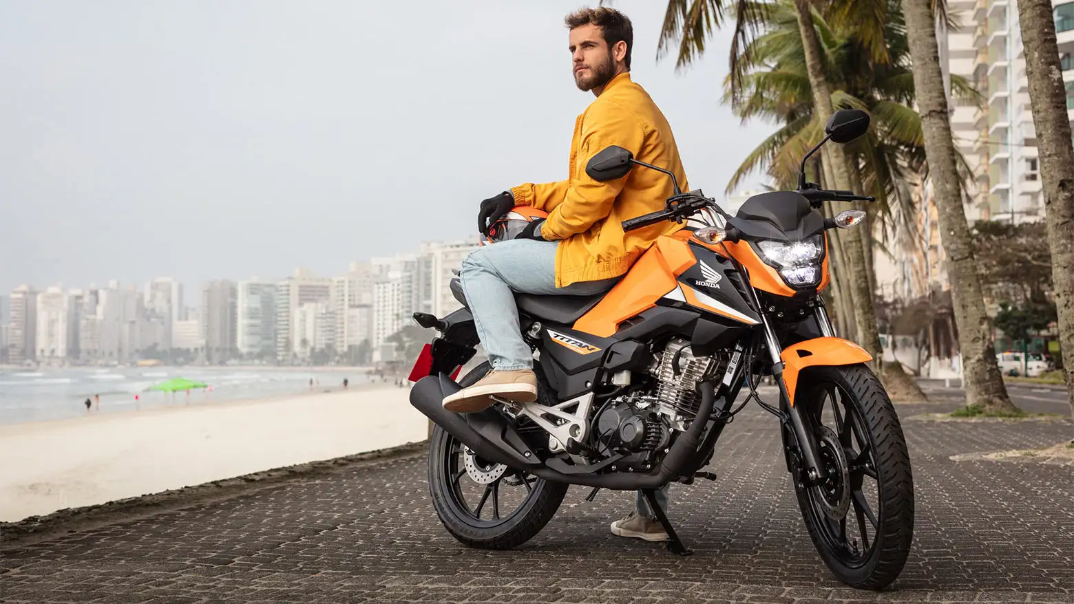 homem-observando-a-paisagem-sentado-na-honda-cg-160-titan-laranja